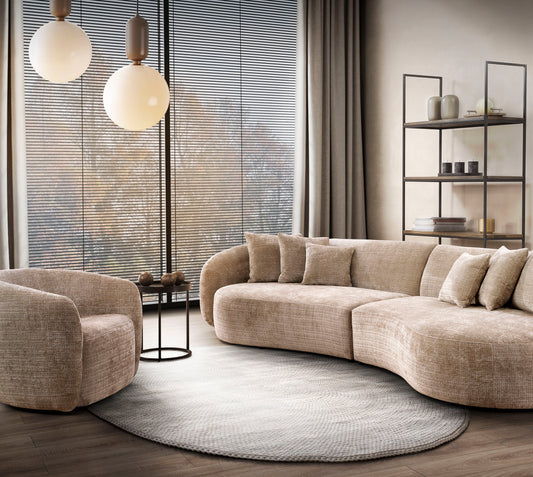 An image of a sofa and chair. The sofa and chair is displayed in a scandi beige colour and is compact and curved to the curve of the circle rug underneath it.
