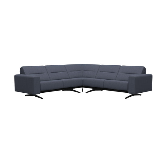 A 'Stressless Stella Fabric Corner Sofa' in gray color with a modern design, featuring a corner sectional shape and black legs.