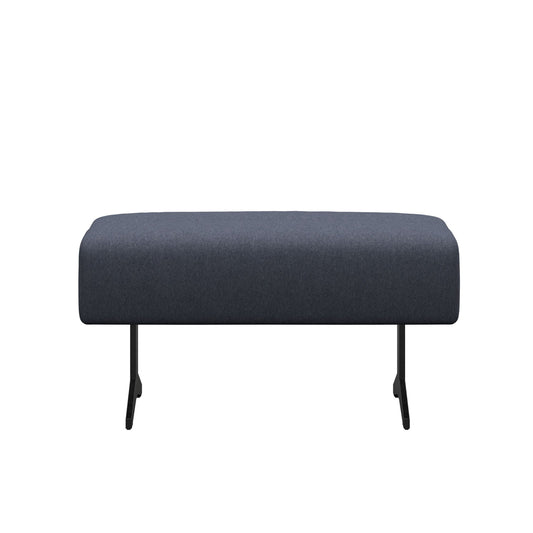 A navy blue fabric ottoman with metal legs, rectangular in shape, likely made by Stressless.