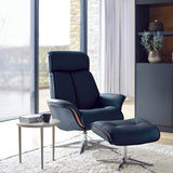 Modern black leather armchair with ottoman in a stylish living room.