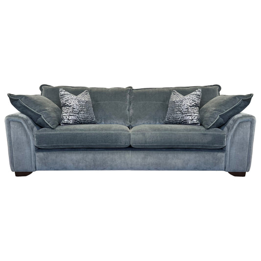 A blue three-seater sofa with two accent pillows, shown with a wooden footrest.