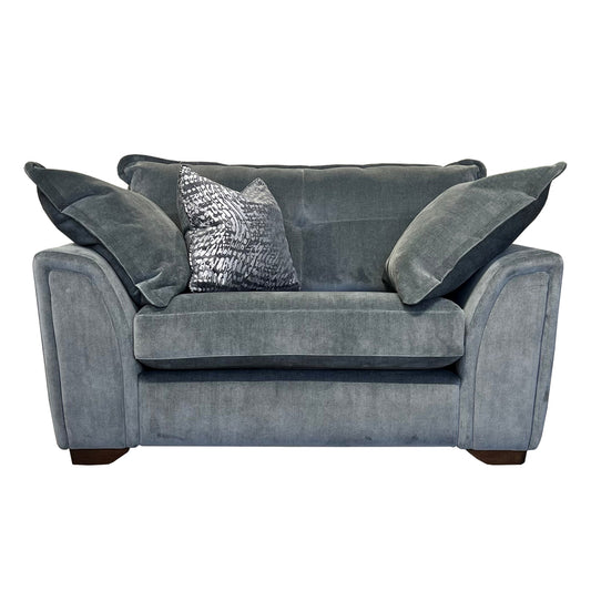 A gray fabric cuddler sofa with pillows, positioned against a white background.