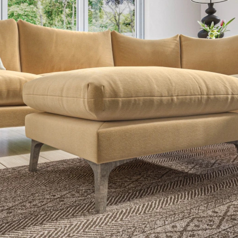 Beige sofa with matching ottoman on a patterned rug
