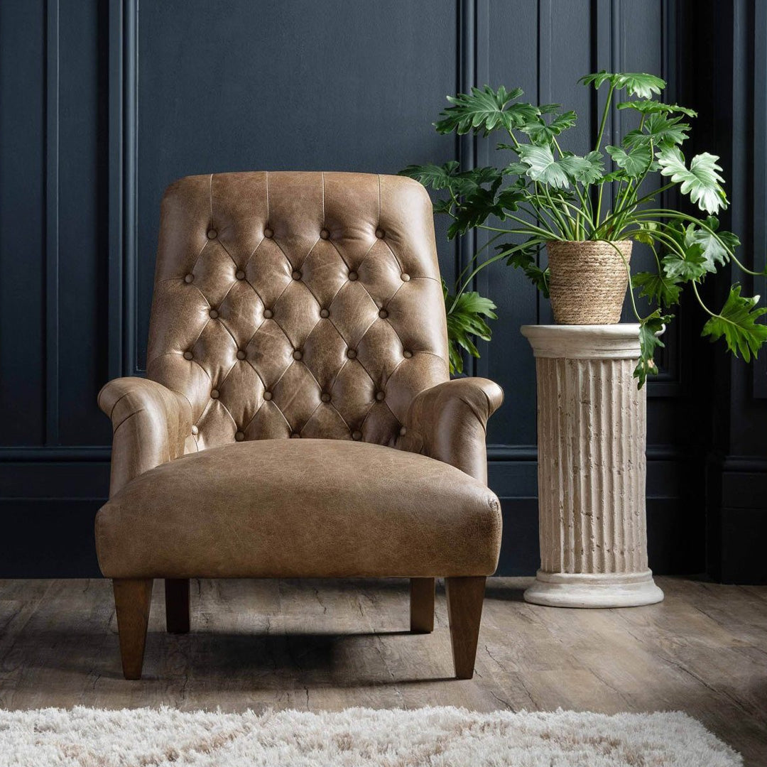 A mid-century style chair with a high buttoned back, slim curved turn out arms, and a smooth seat base, upholstered in a brown fabric, with a solid rubberwood frame and foam seat suspension.