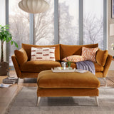 Modern living room with brown sofa, ottoman, and fireplace.