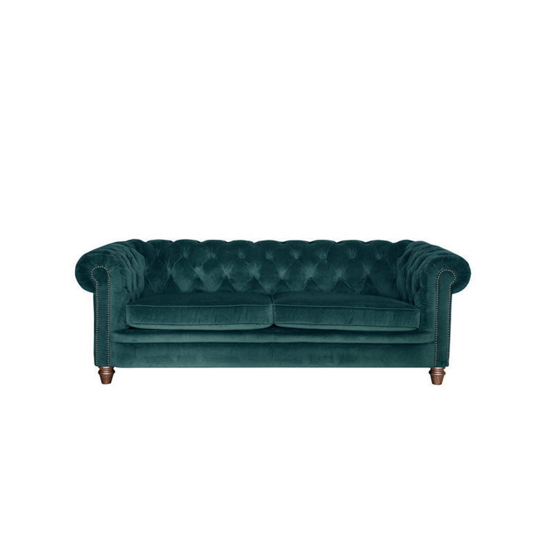 An image of the Abraham Junior Large Sora in a green coloured velvet fabric. The sofa is a cut out on a white background .