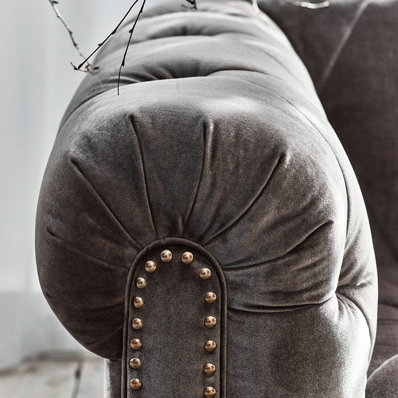 A lifestyle image of the Luisa sofa. The image is a close up of the Luisa arm with a Grey Fabric. 