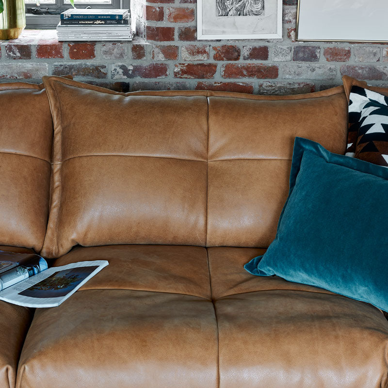 A close up image of the brown leather Tod Corner Sofa. 